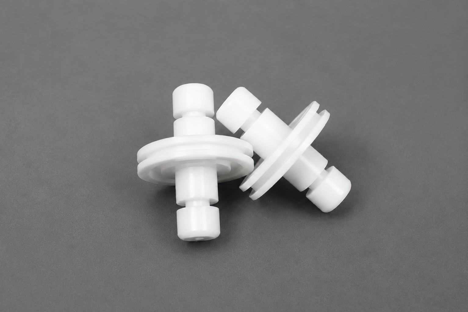 White POM-C plastic machined part with cylindrical geometry and machined grooves